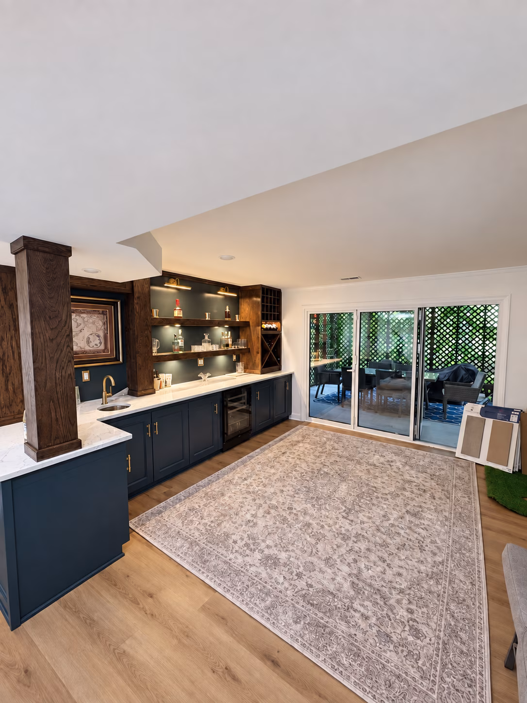 Finished home bar and LVP flooring beside the new glass bi-fold door leading to the outdoor seating area.